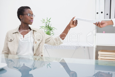 Cheerful woman taking paper of her colleague