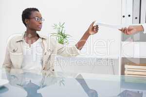 Cheerful woman taking paper of her colleague