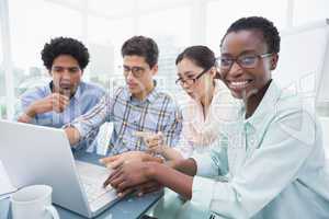 Casual business team having a meeting using laptop