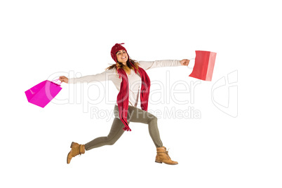 Smiling brunette jumping with gifts bags