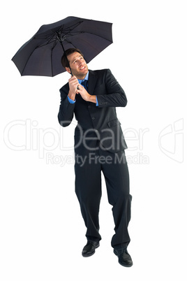 Businessman standing under black umbrella