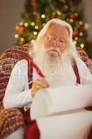 Santa claus writing list on the armchair