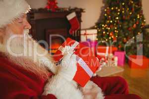 Santa claus writing on a red gift