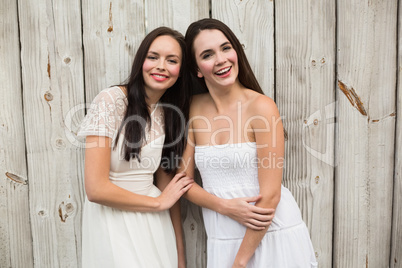 Pretty friends smiling in white dresses