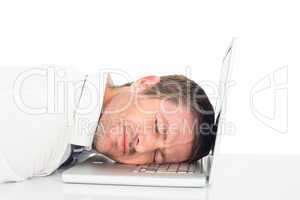 Tired businessman resting on laptop