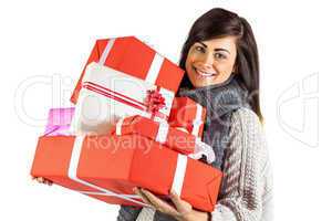 Smiling brunette holding pile of gifts