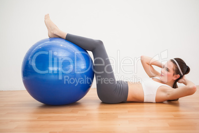 Fit brunette working out with exercise ball