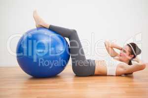 Fit brunette working out with exercise ball