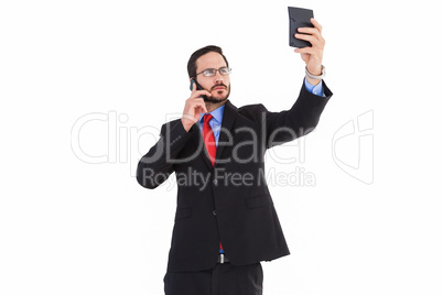 Businessman holding calculator while talking on phone