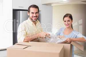 Young couple unpacking boxes in kitchen