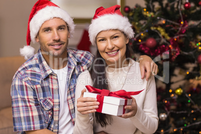 Festive couple holding christmas gifts