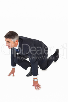 Businessman with hands and one knee on the floor