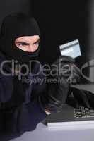 Hacker in balaclava spending money online