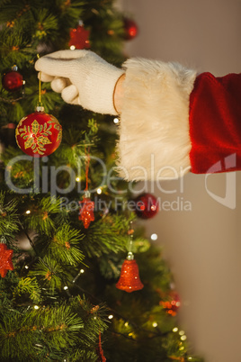 Hand of santa hanging a bauble