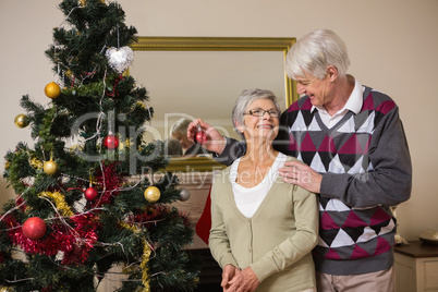 Senior couple decorating their christmas tree