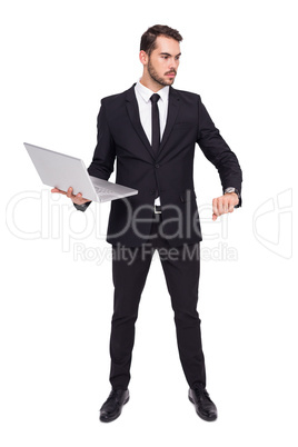 Focused businessman in suit holding laptop