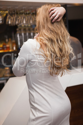 Rear view of pretty blonde girl posing hands in the hair