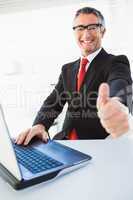 Positive businessman in suit with thumbs up