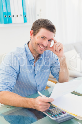 Smiling businessman working on his finances at his desk