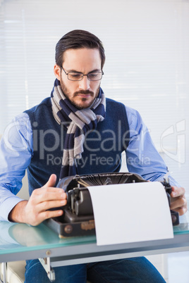 Serious businessman working on typewriter