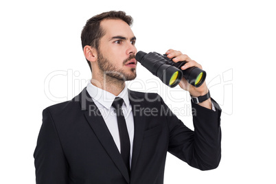 Surprised businessman standing and holding binoculars