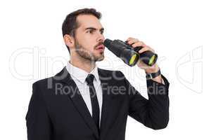 Surprised businessman standing and holding binoculars