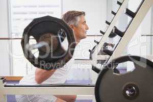 Fit man lifting heavy barbell