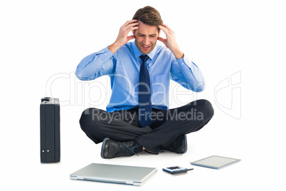 Businessman sitting on the floor with headache