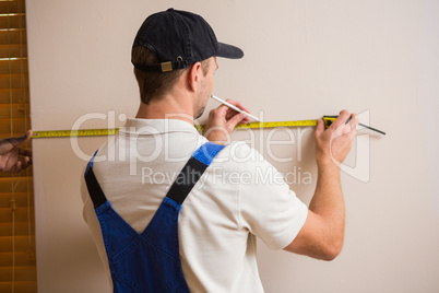 Construction worker using measuring tape