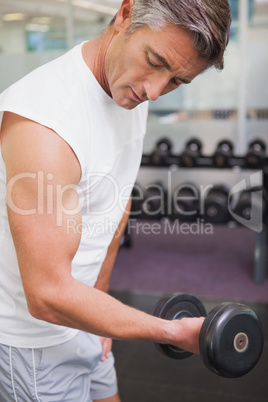 Fit man lifting heavy black dumbbell