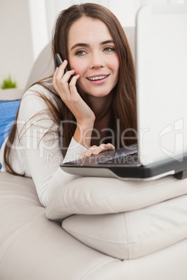 Pretty brunette using laptop on the couch