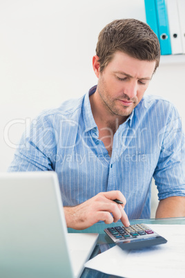 A businessman working on his finances at his desk