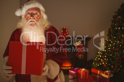 Surprised santa claus delivering a glowing gift