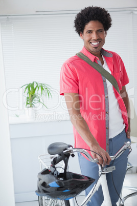 Happy businessman standing with his bike