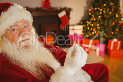 Smiling santa holding engagement ring