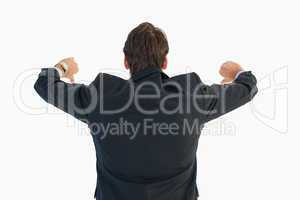 Rear view of businessman gesturing thumbs down