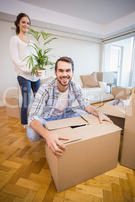 Cute couple unpacking cardboard boxes