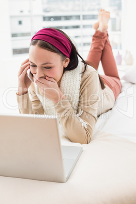 Pretty brunette using laptop on bed Pretty brunette using laptop on bed