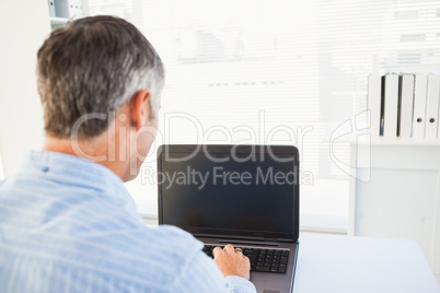 Man with grey hair using his laptop