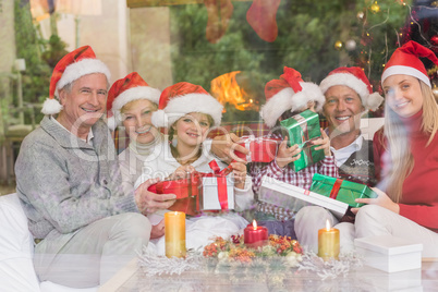 Multi generation family holding a lot of presents on sofa