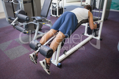 Fit man using weights machine for legs