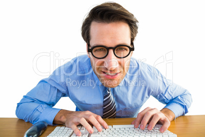 Businessman typing on his keyboard wearing glasses