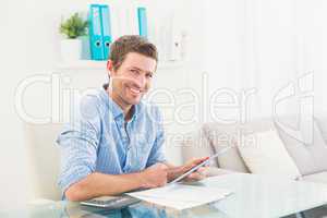 Casual businessman using tablet at desk