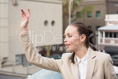 Young businesswoman hailing a cab