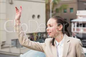 Young businesswoman hailing a cab