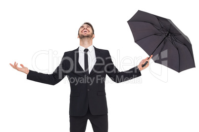 Happy businessman holding umbrella