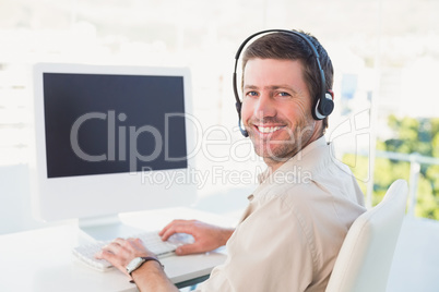 Businessman in headset smiling at camera