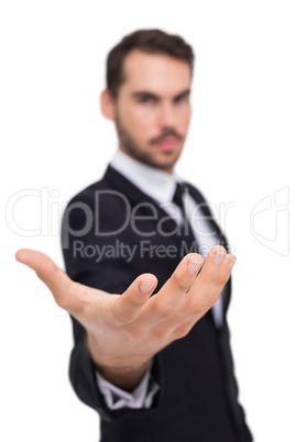 Businessman holding hand out in presentation