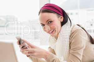 Pretty brunette smiling at camera on bed