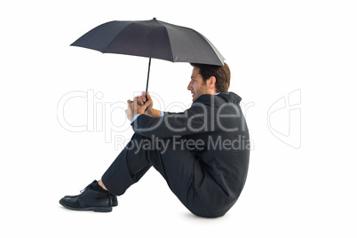Businessman holding umbrella sitting on the floor Businessman holding umbrella sitting on the floor